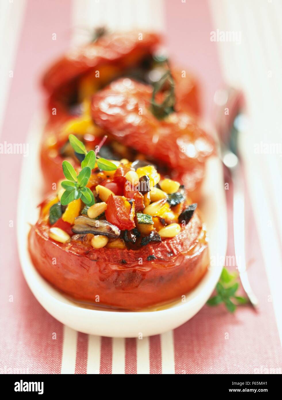 Tomaten gefüllt mit gegrilltem Gemüse und Pinienkernen Stockfoto