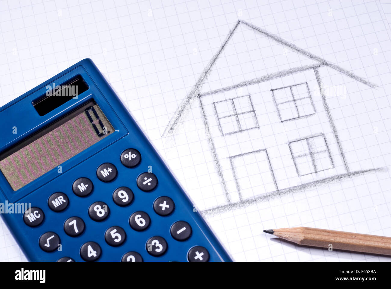 Taschenrechner und Kugelschreiber liegen neben der Skizze eines Hauses. Stockfoto