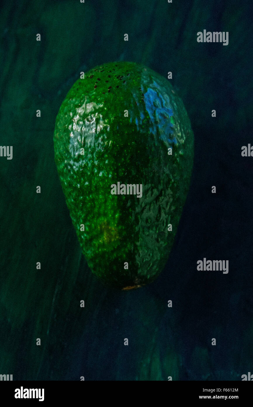 Portrait einer Avocado auf einem Blau Grün Holz wieder Stockfoto