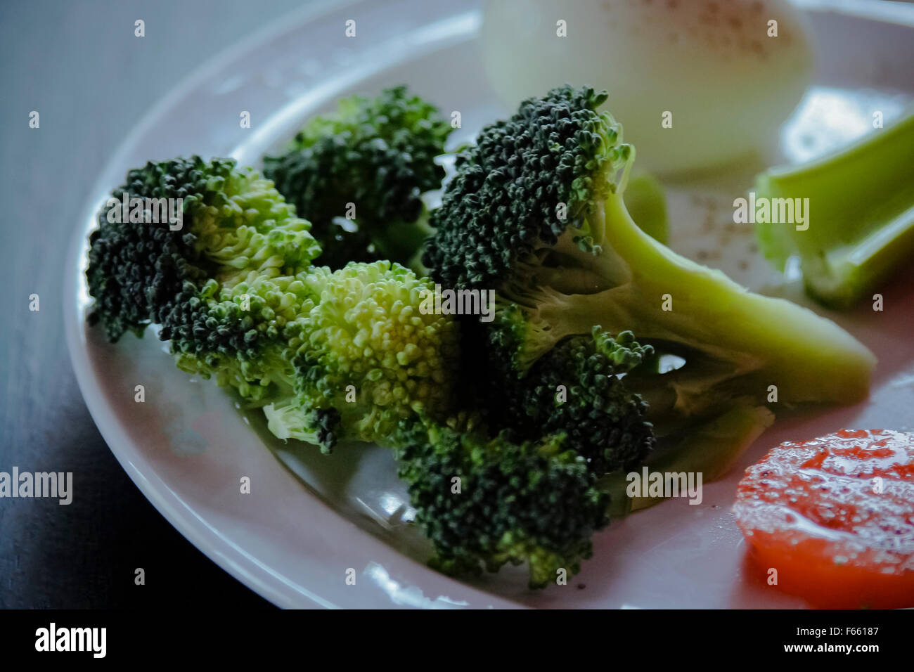Frischen Brokkoli auf ein bläuliches grün Hintergrund mit anderen gesunden Zutaten. low-key Beleuchtung, geringe Tiefenschärfe Stockfoto
