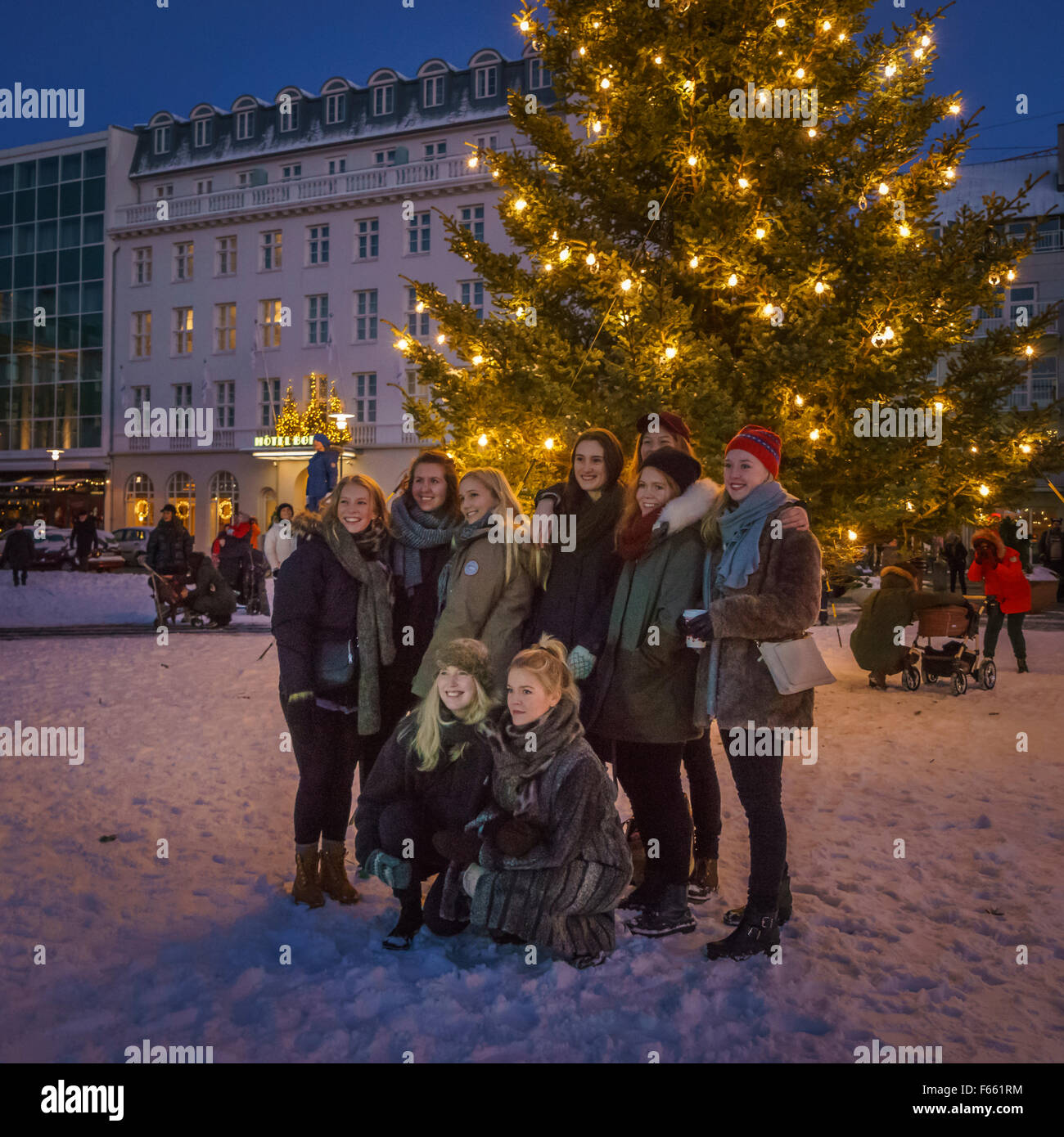 Menschen fotografieren durch den großen Weihnachtsbaum, Austurvollur Platz, Reykjavik, Island Stockfoto