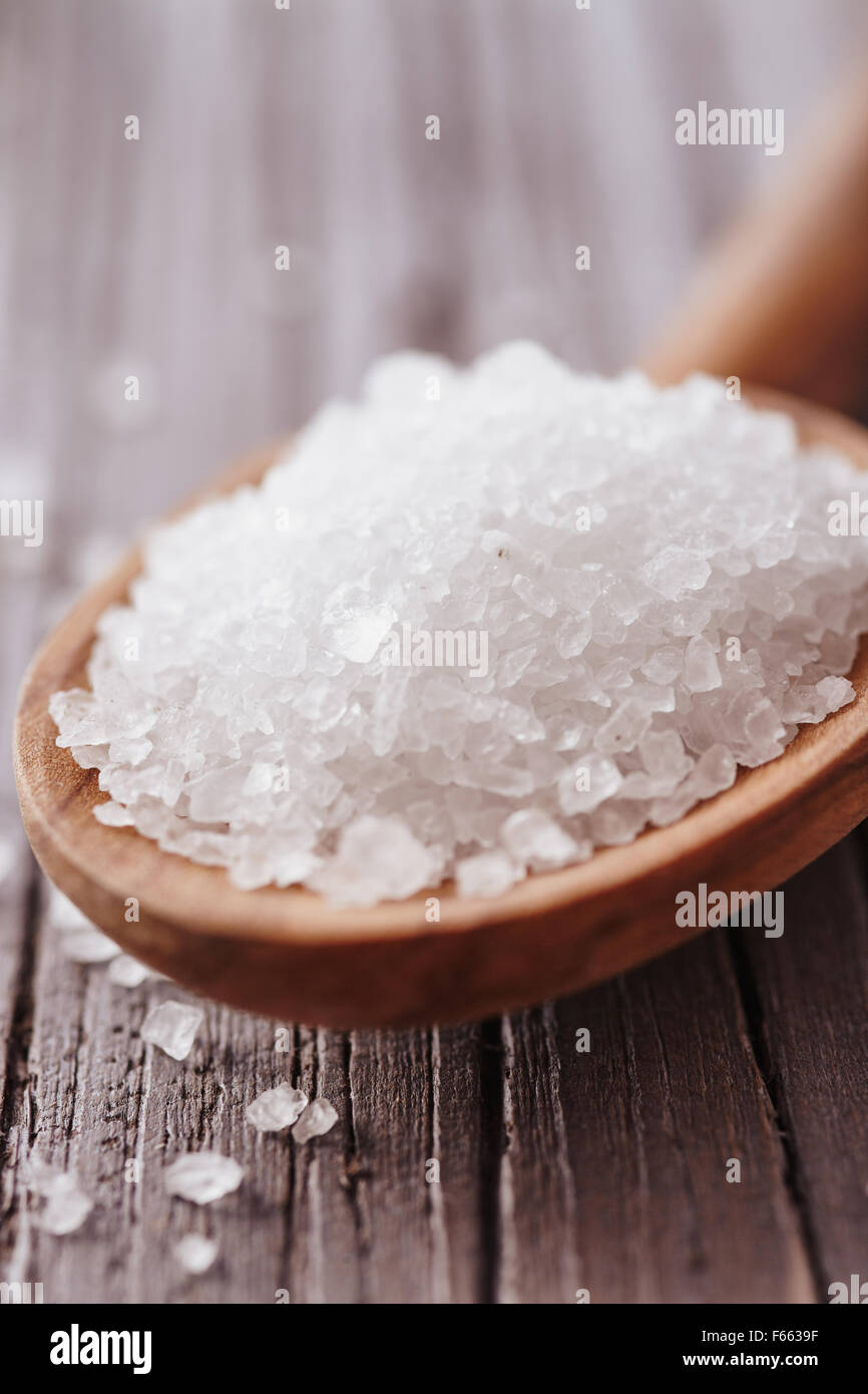 Salzkristalle in einem Holzlöffel Stockfoto