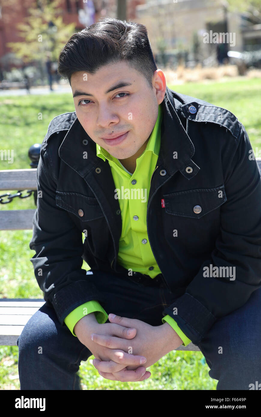 Porträt eines jungen Mannes trägt ein grünes T-Shirt mit einem leichten schwarzen Jacke direkt in die Kamera. Stockfoto