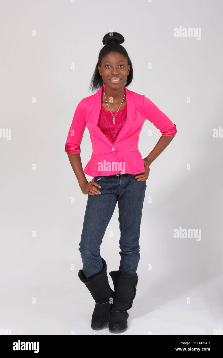 Portrait einer jungen afrikanischen amerikanischen Mädchen mit einem rosa Hemd und Jeans auf einem weißen Hintergrund. Stockfoto