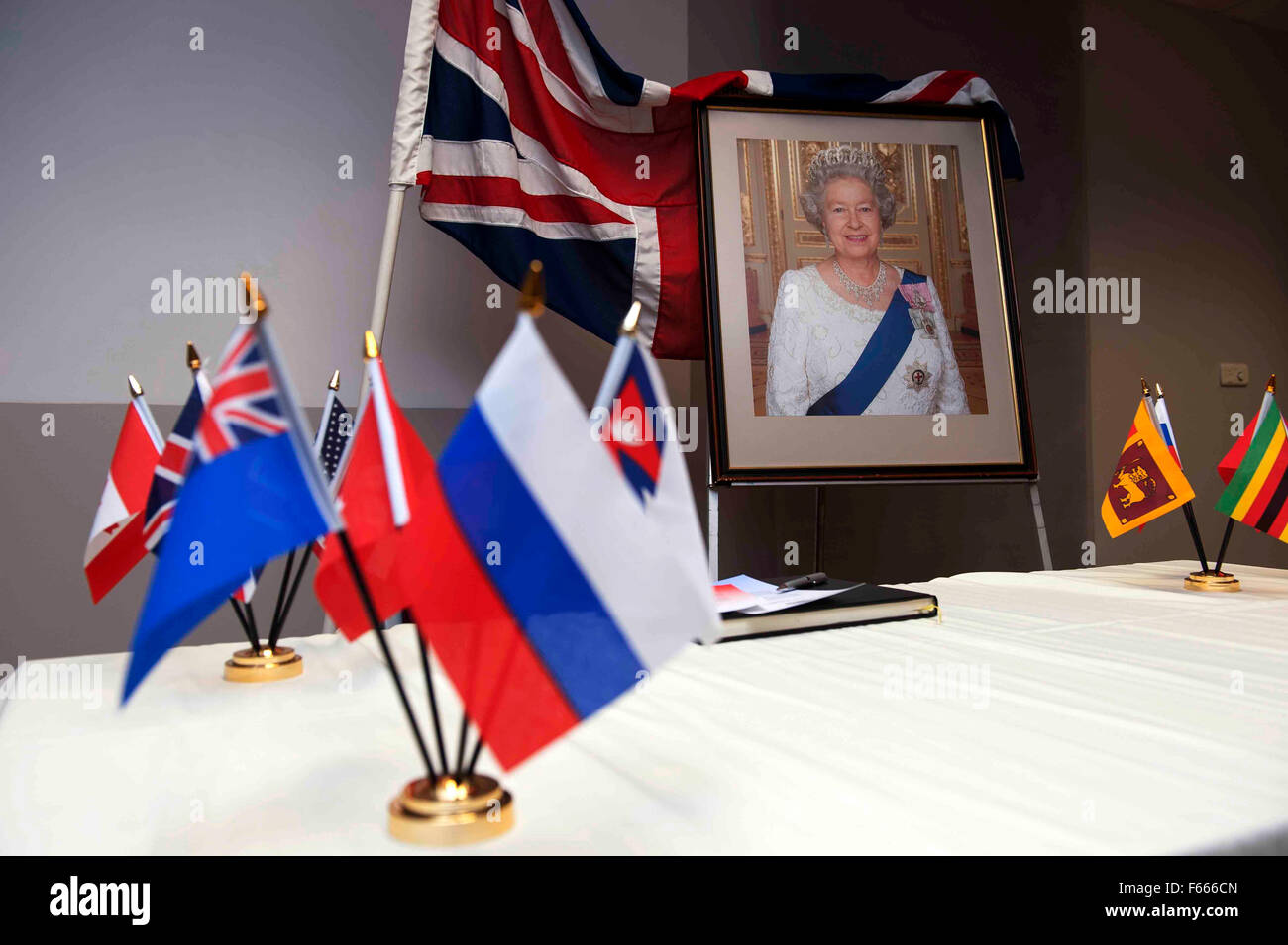 Ein Porträt der Königin von England auf einem Tisch während einer Einbürgerungszeremonie mit den Union Jack und Common Wealth Flaggen geschmückt. Stockfoto
