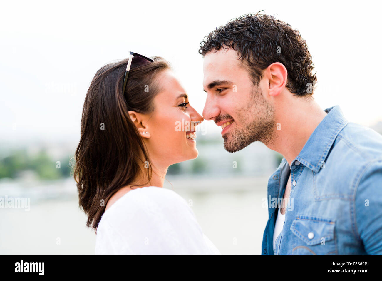 Junge schöne Paar Nasen als Zeichen der Liebe und küssen einander reiben Stockfoto