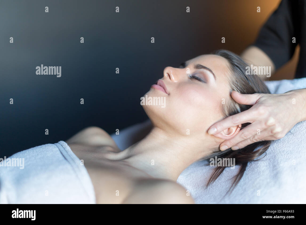 Behandlung von Gesicht, eine schöne, junge Frau auf der Massagebank liegen Masseur Stockfoto