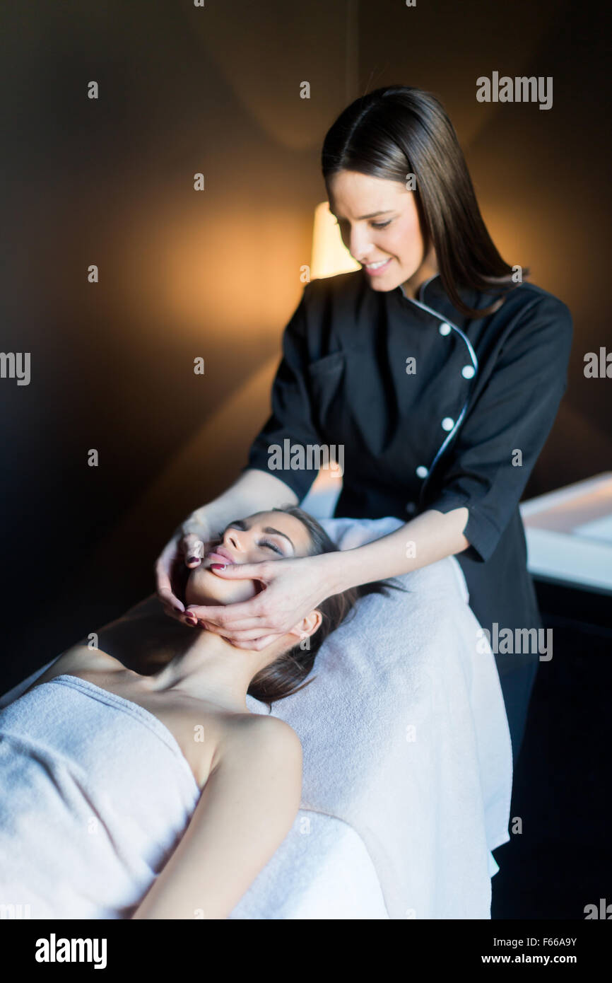 Behandlung von Gesicht, eine schöne, junge Frau auf der Massagebank liegen Masseur Stockfoto
