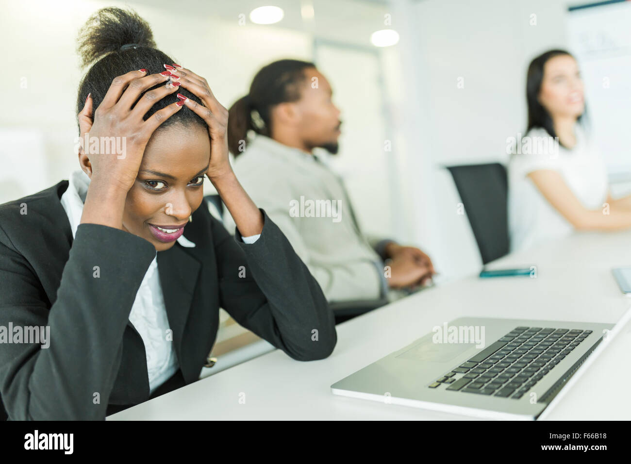 Jung betonte Geschäftsfrau mit einer Migräne zu kämpfen, während einer Konferenz Stockfoto