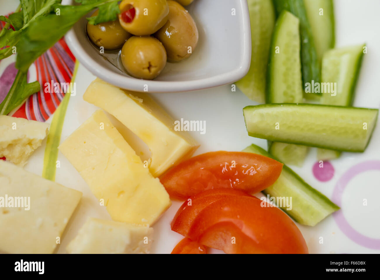 Gelber Käse, Tomaten und Oliven zum Frühstück Stockfoto