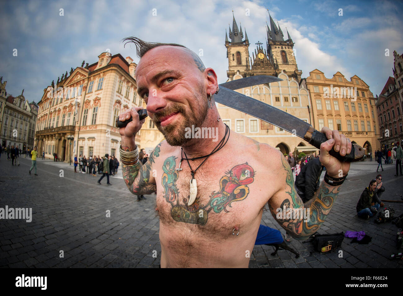 Ein Mann mit Tattoos mit einem Irokesenschnitt schwingt sein Schwert in der Altstadt in Prag Stockfoto