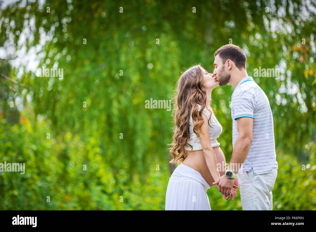Glückliches junges Paar erwartet Baby im Sommerpark Stockfoto