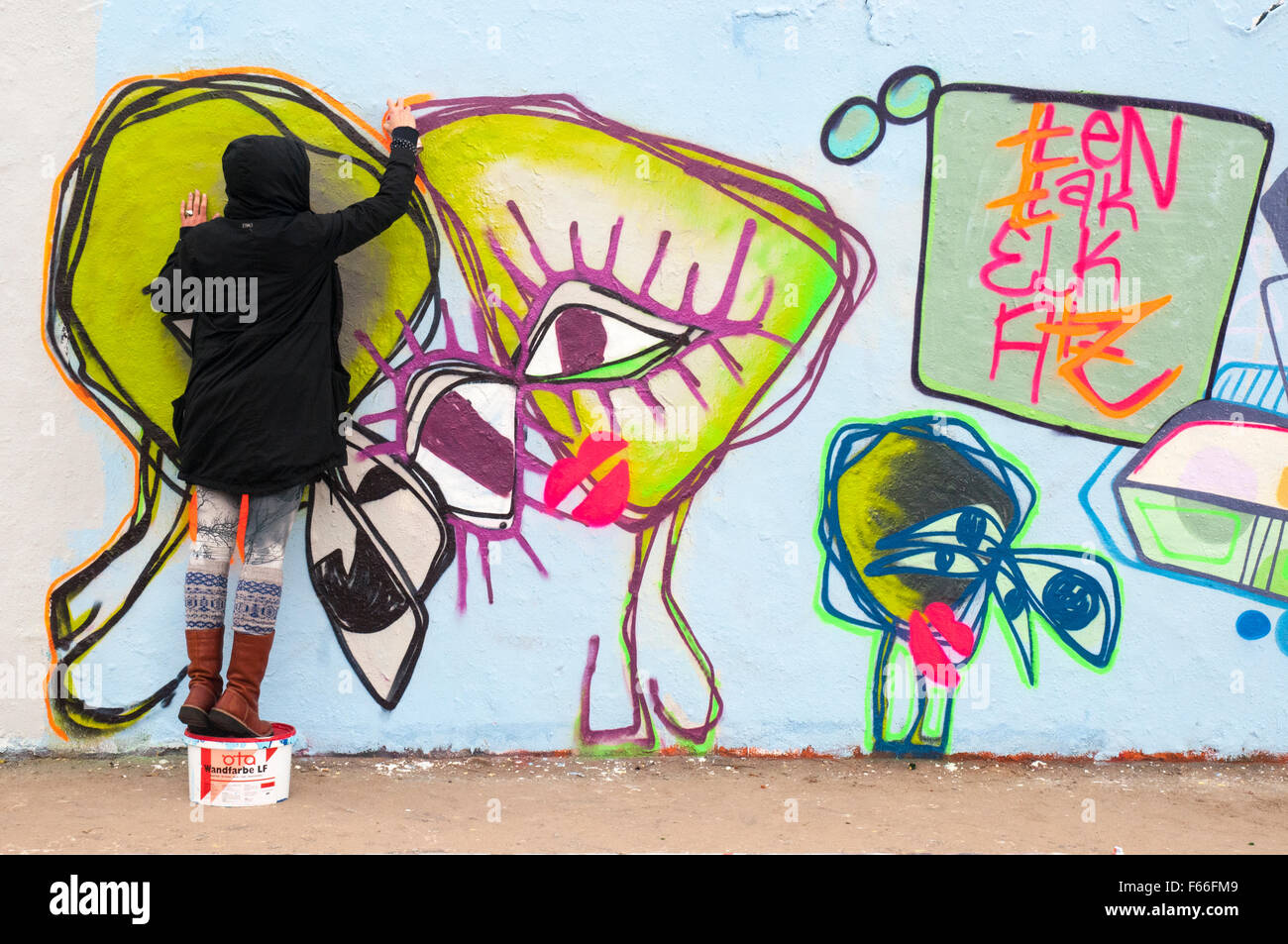 Street Art Künstler bei der Arbeit auf ein Überbleibsel der Berliner Mauer am Mauerpark, Prenzlauer Berg Stockfoto