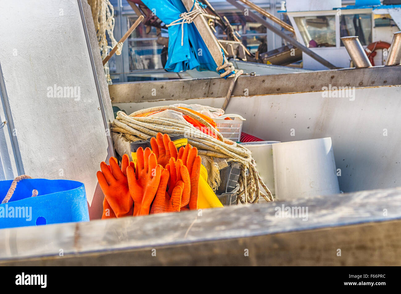Fischer orange Handschuhe zum Trocknen auf einem Boot gehängt Stockfoto