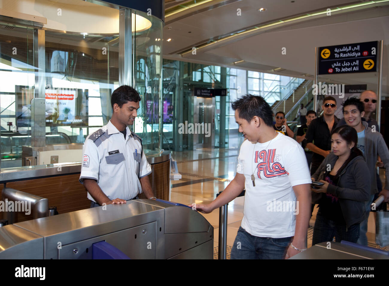 Mitarbeiter unterstützen Passagiere auf der Dubai Metro Stockfoto