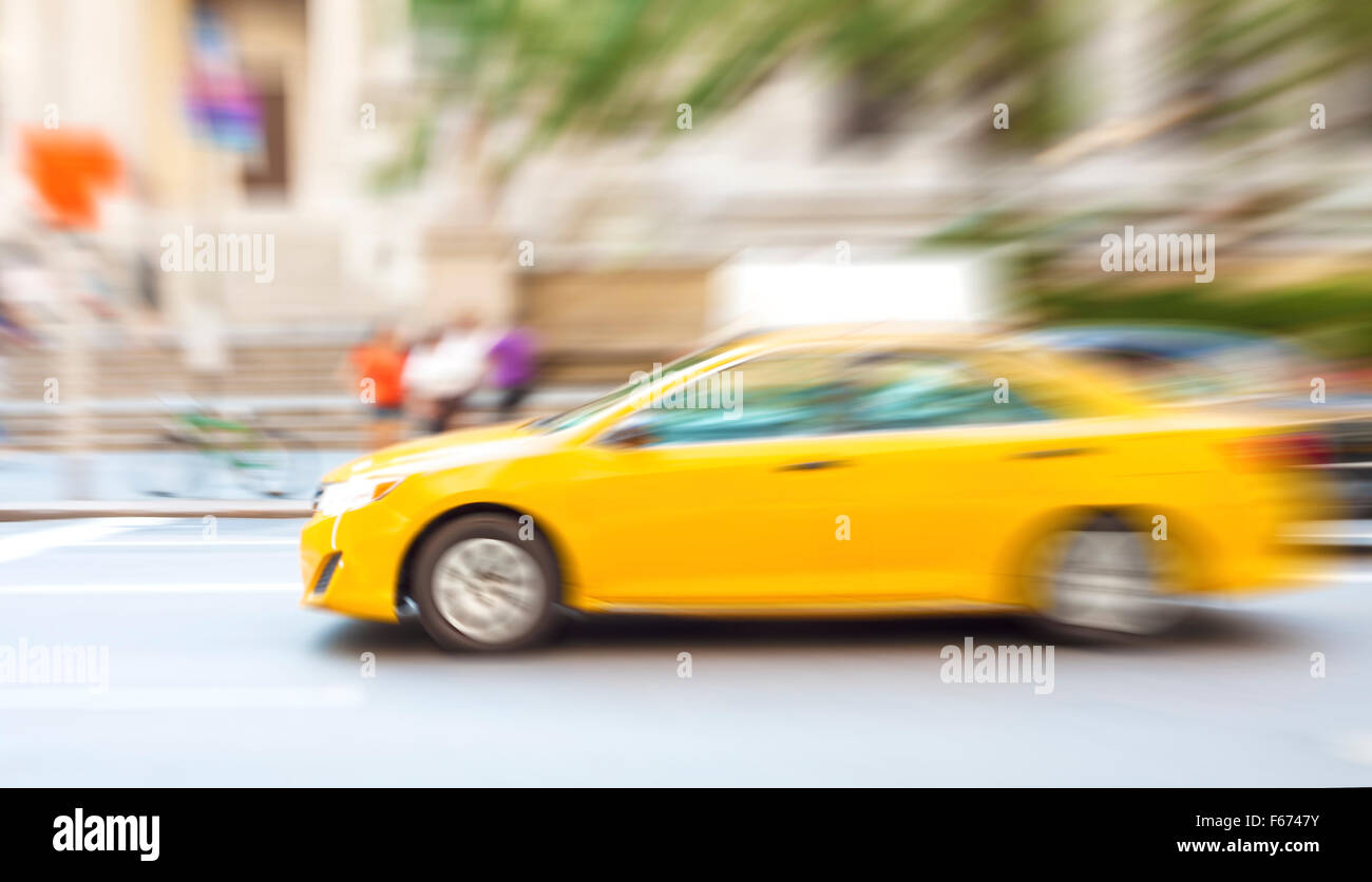 Bewegung verwischt gelbes Taxi auf einer Stadtstraße. Stockfoto