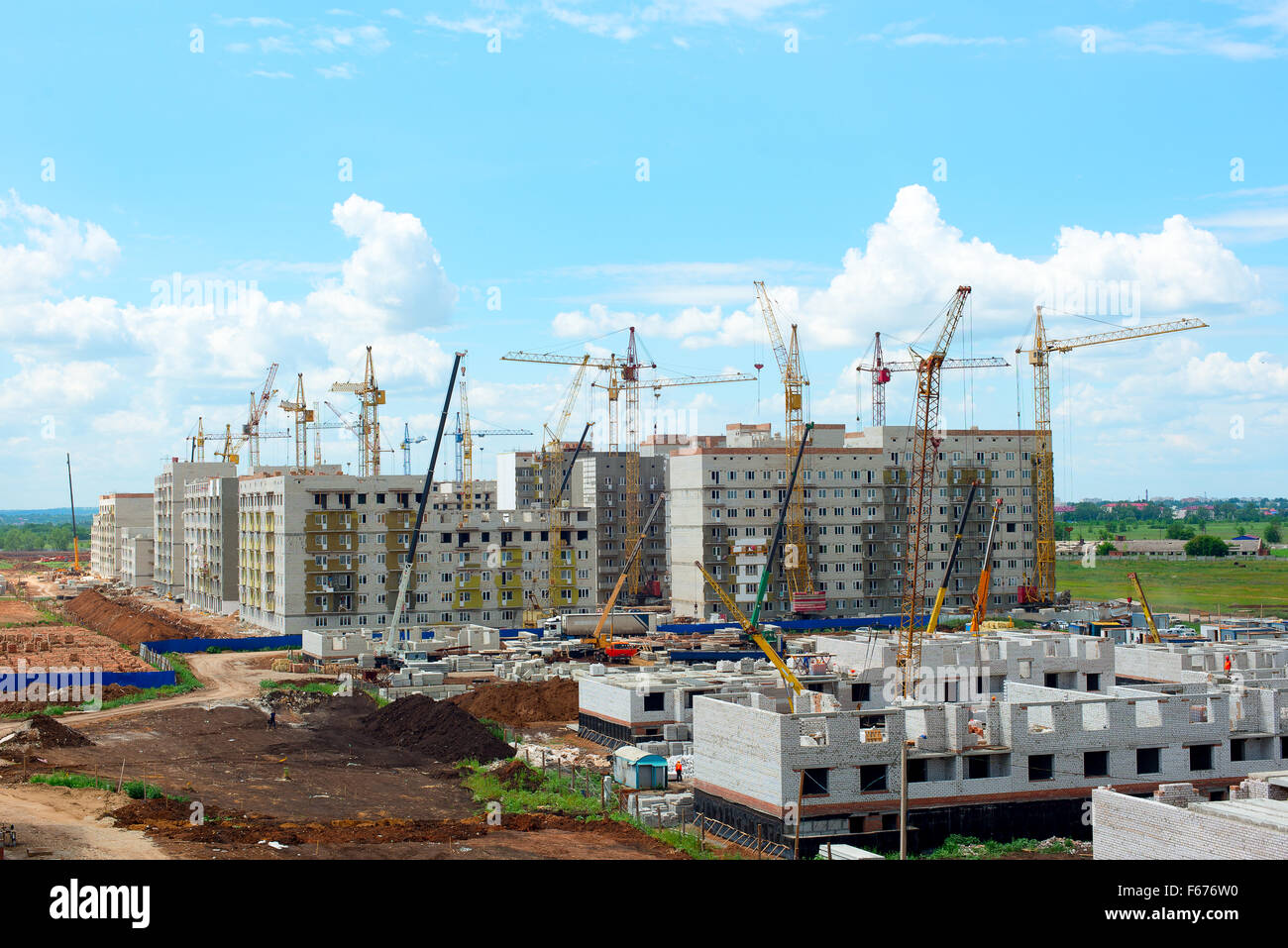 Bau der Backsteinhäuser mit Kränen anzeigen Stockfoto