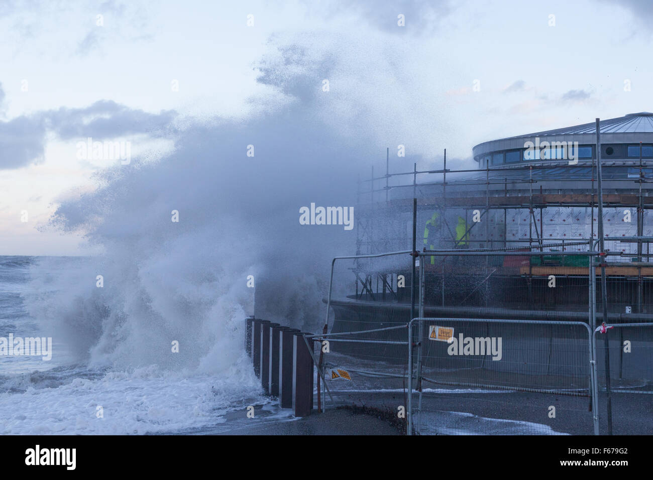 Aberystwyth, Wales, UK. 13. November 2015.  Sturm-Abigail Wimpern bei Aberystwyth Vormittag mit wütenden Wellen während zwei Bauherren Arbeit auf dem Gerüst der neue Musikpavillon an der Promenade versuchen. Bildnachweis: Ian Jones/Alamy Live-Nachrichten Stockfoto