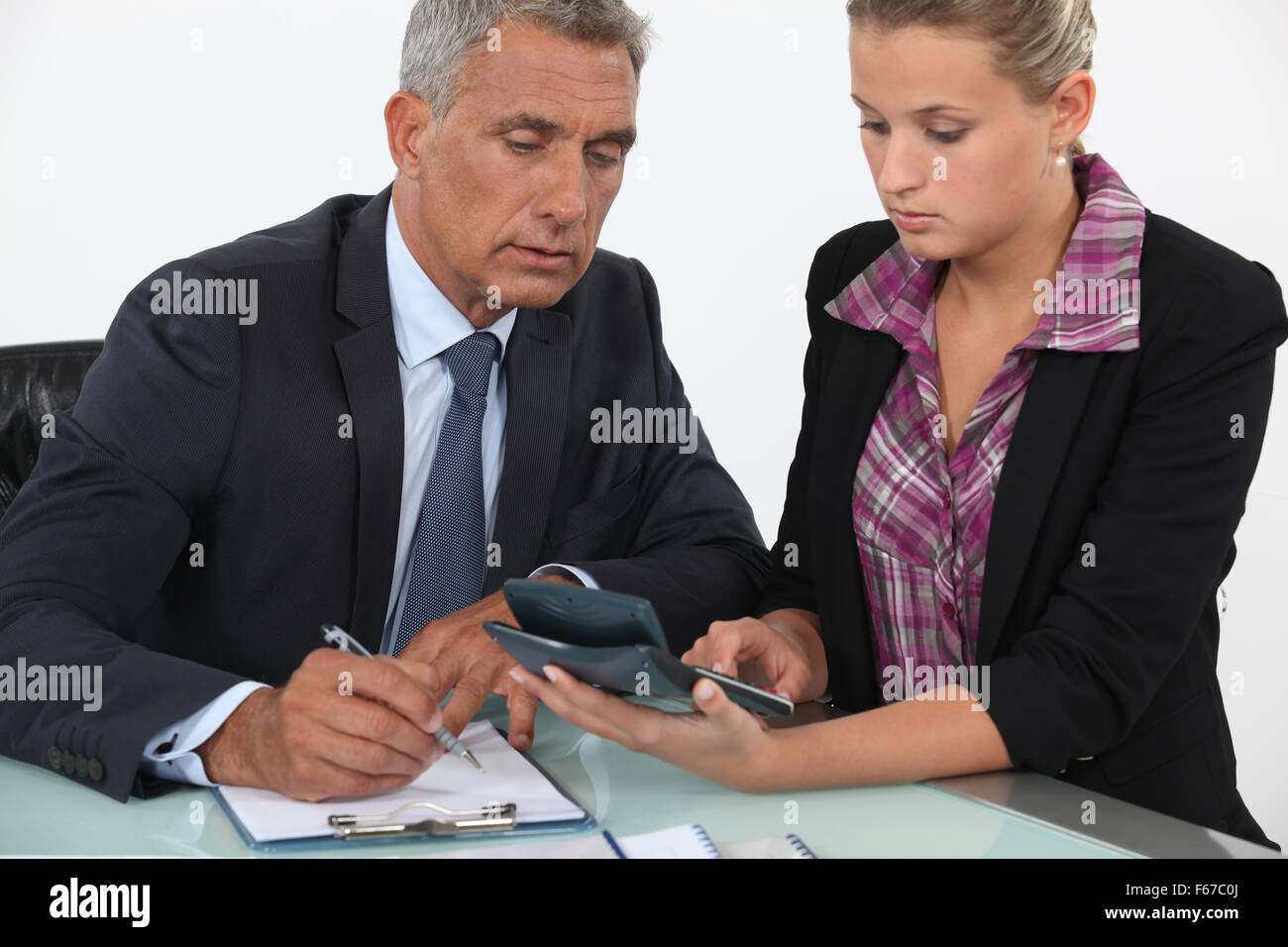 Geschäftsmann und Frau Verwendung eines Taschenrechners Stockfoto