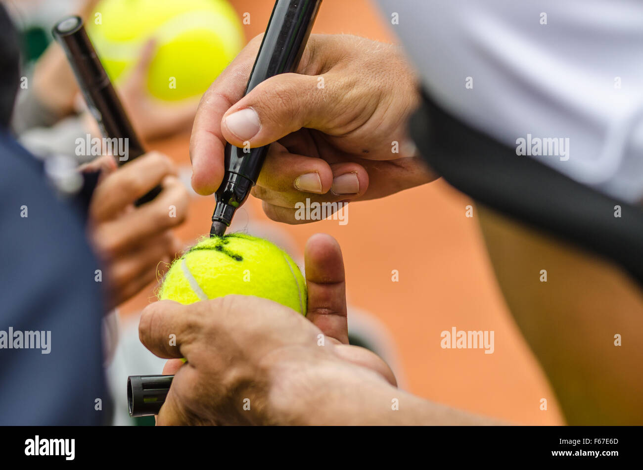 Tennis Spieler Zeichen Autogramm auf einem Tennisball nach Sieg, Nahaufnahme Foto zeigt Tennisball und Hände eines Mannes, die Signatur zu machen. Stockfoto