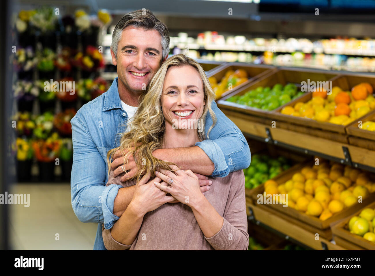 Lächelnde paar umarmt in Frucht-Gang Stockfoto