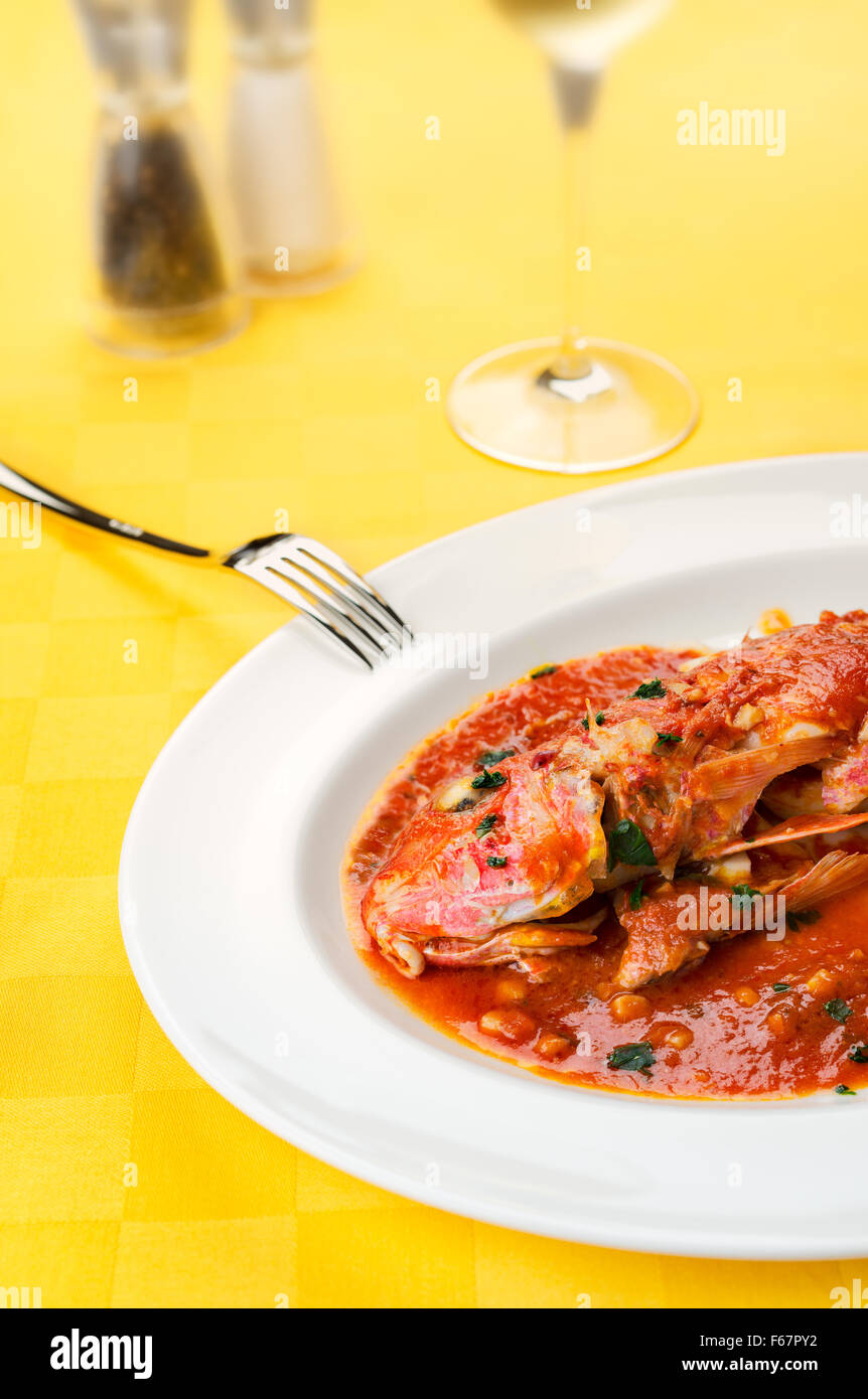 Rote Meerbarben Meeresfrüchte italienischen traditionellen Gourmet-Rezept mit Tomaten, Knoblauch, Olivenöl mit Glas Wein, Salz und Pfeffer auf einen Schrei Stockfoto
