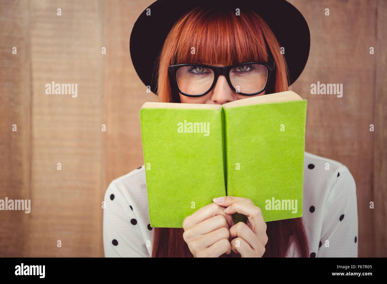 Hipster Frau hinter ein grünes Buch Stockfoto