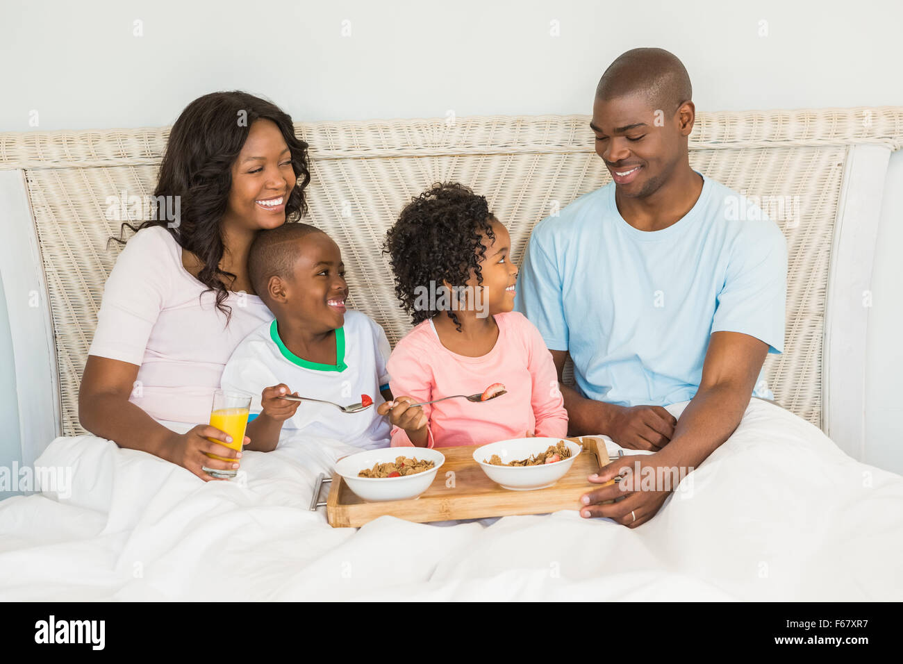 Glückliche Familie zusammen im Bett frühstücken Stockfoto