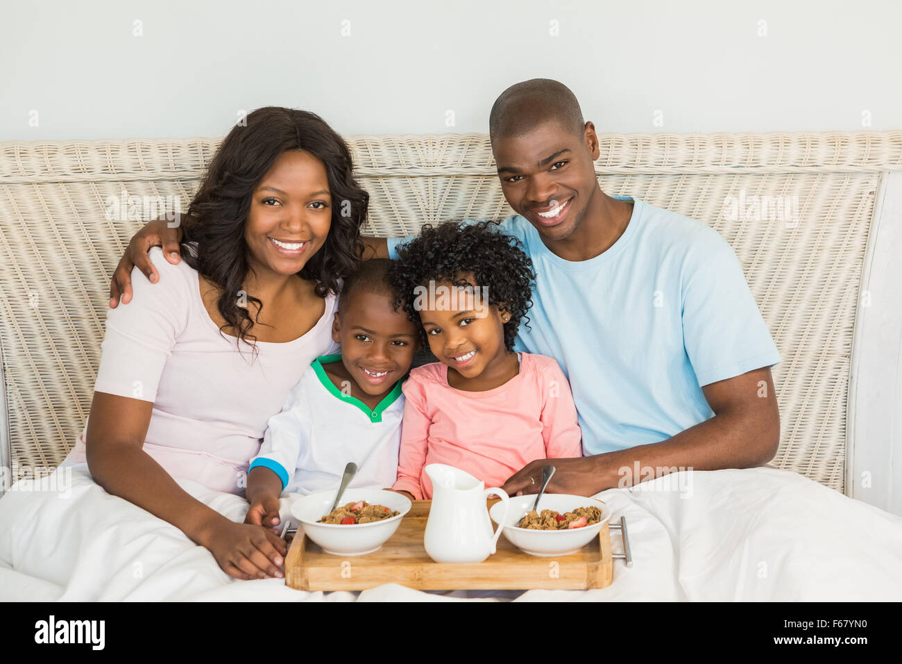 Glückliche Familie zusammen im Bett frühstücken Stockfoto