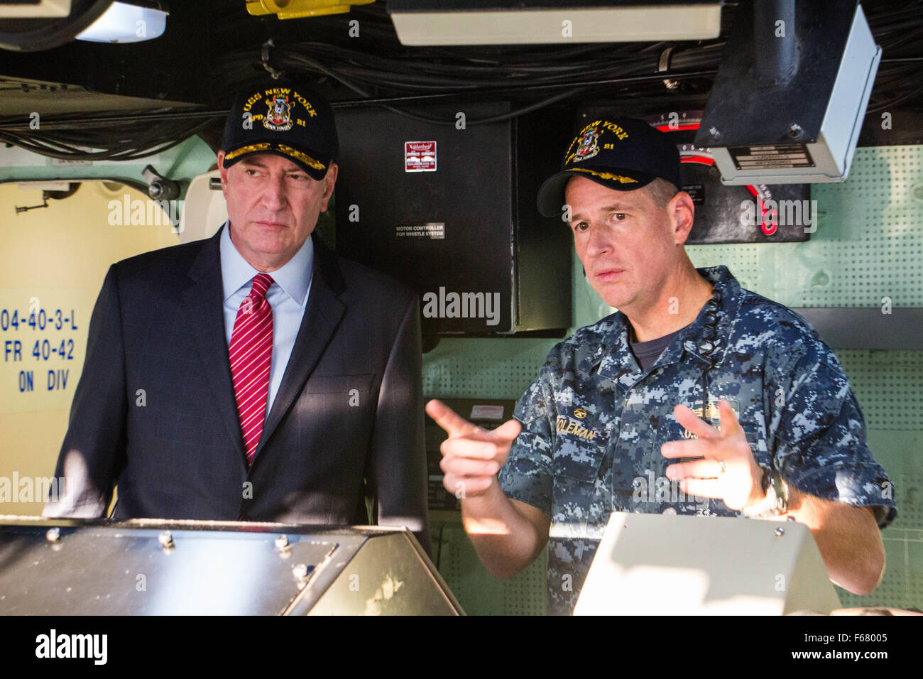 New Yorks Bürgermeister Bill de Blasio (links) hört zu, als Kommandant der USS New York Captain Kenneth Coleman Betriebsabläufe an Bord während eines Besuchs erklärt 13. November 2015 in New York City, New York. Stockfoto