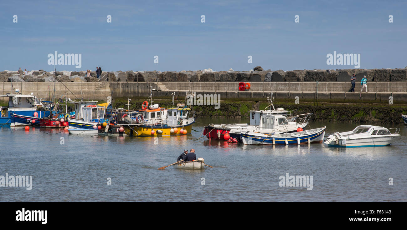 Sonnigen Sommertag mit blauem Himmel, kleine Fischerboote im Tierheim Wellenbrecher und ruhigen, malerischen Meer Hafen, Staithes, North Yorkshire, GB, UK festgemacht. Stockfoto