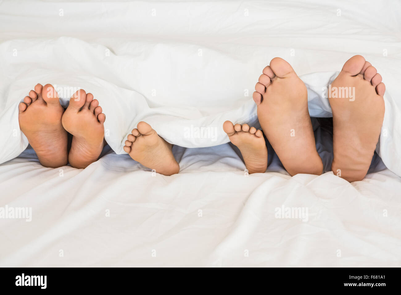 Familys Füße aus einem Bett Stockfoto