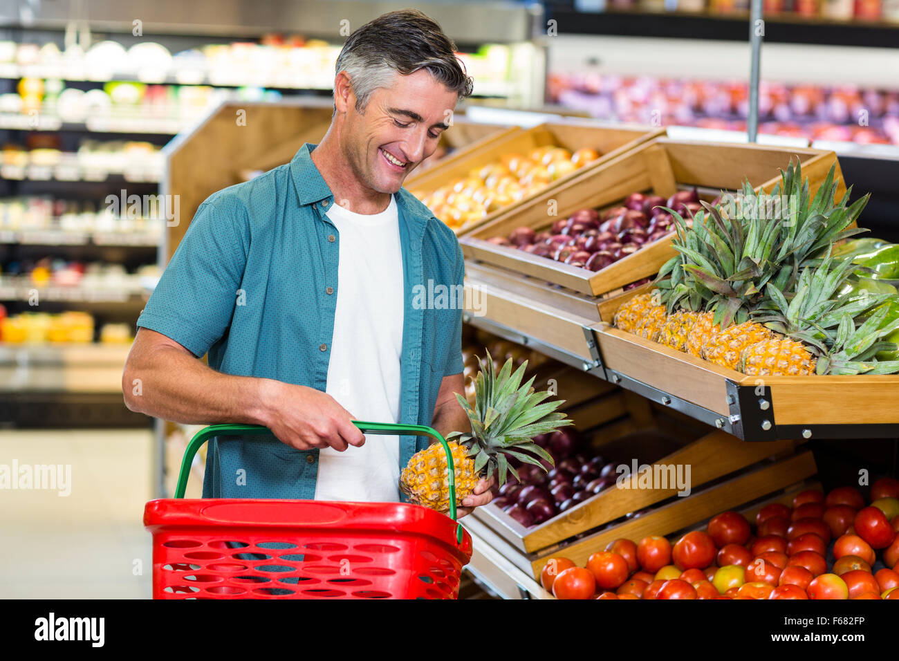 Lächelnder Mann Wahl Ananas Stockfoto