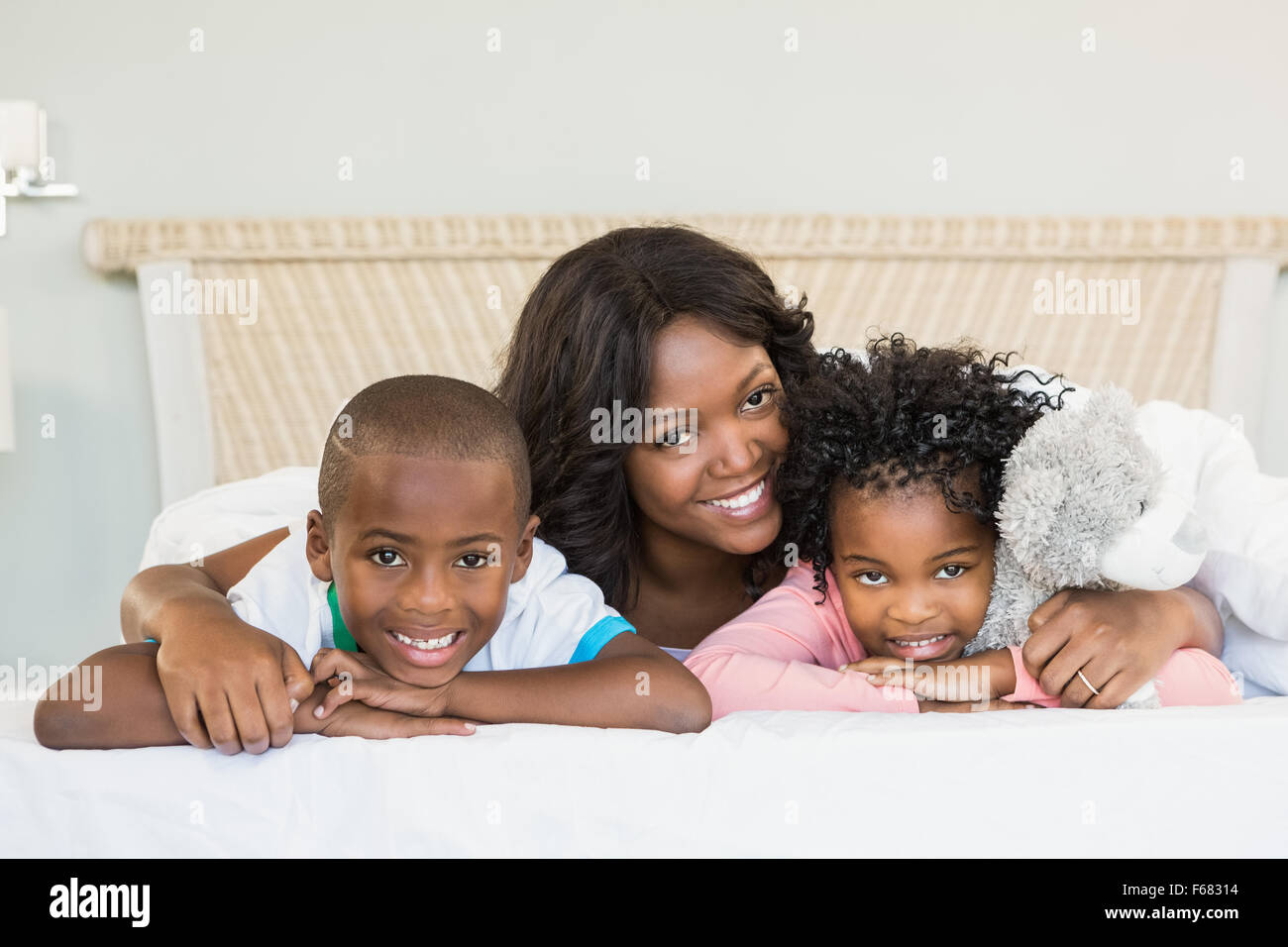 Mutter und Kinder auf Bett liegend Stockfoto