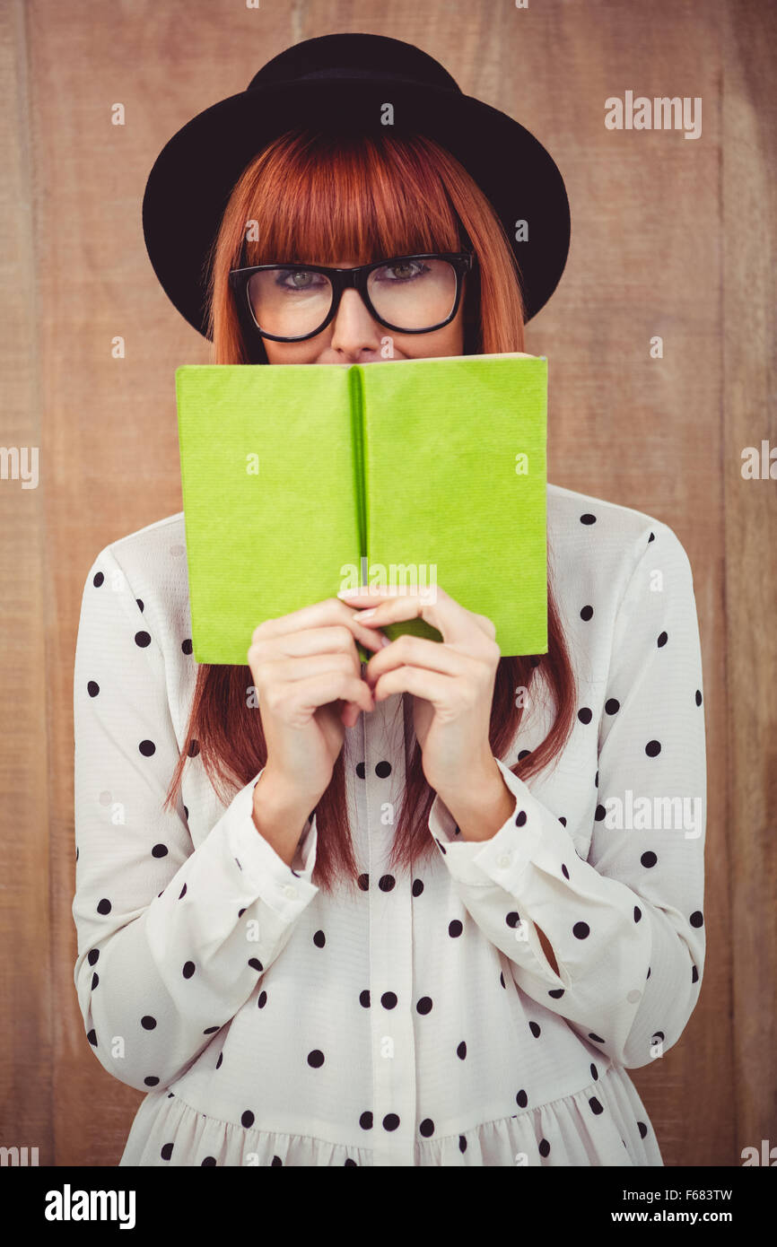 Hipster Frau hinter ein grünes Buch Stockfoto