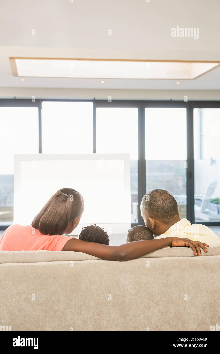 Schulter-Blick über lässige Familie vor dem Fernseher Stockfoto