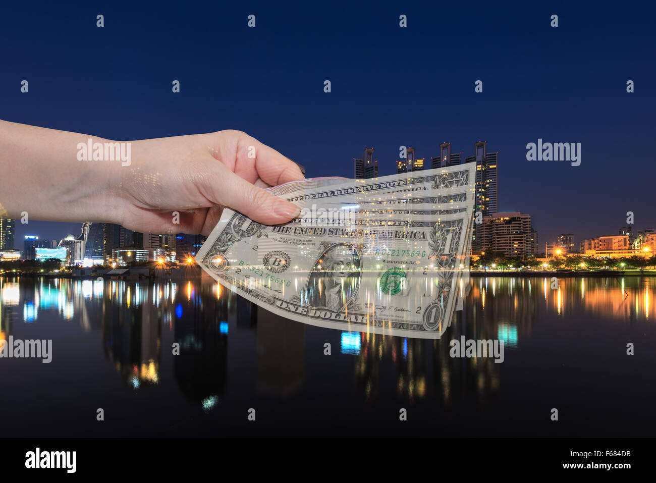 Doppelbelichtung von weiblicher Hand geben Geld Dollar über Stadt Nacht hellen Hintergrund. Stockfoto