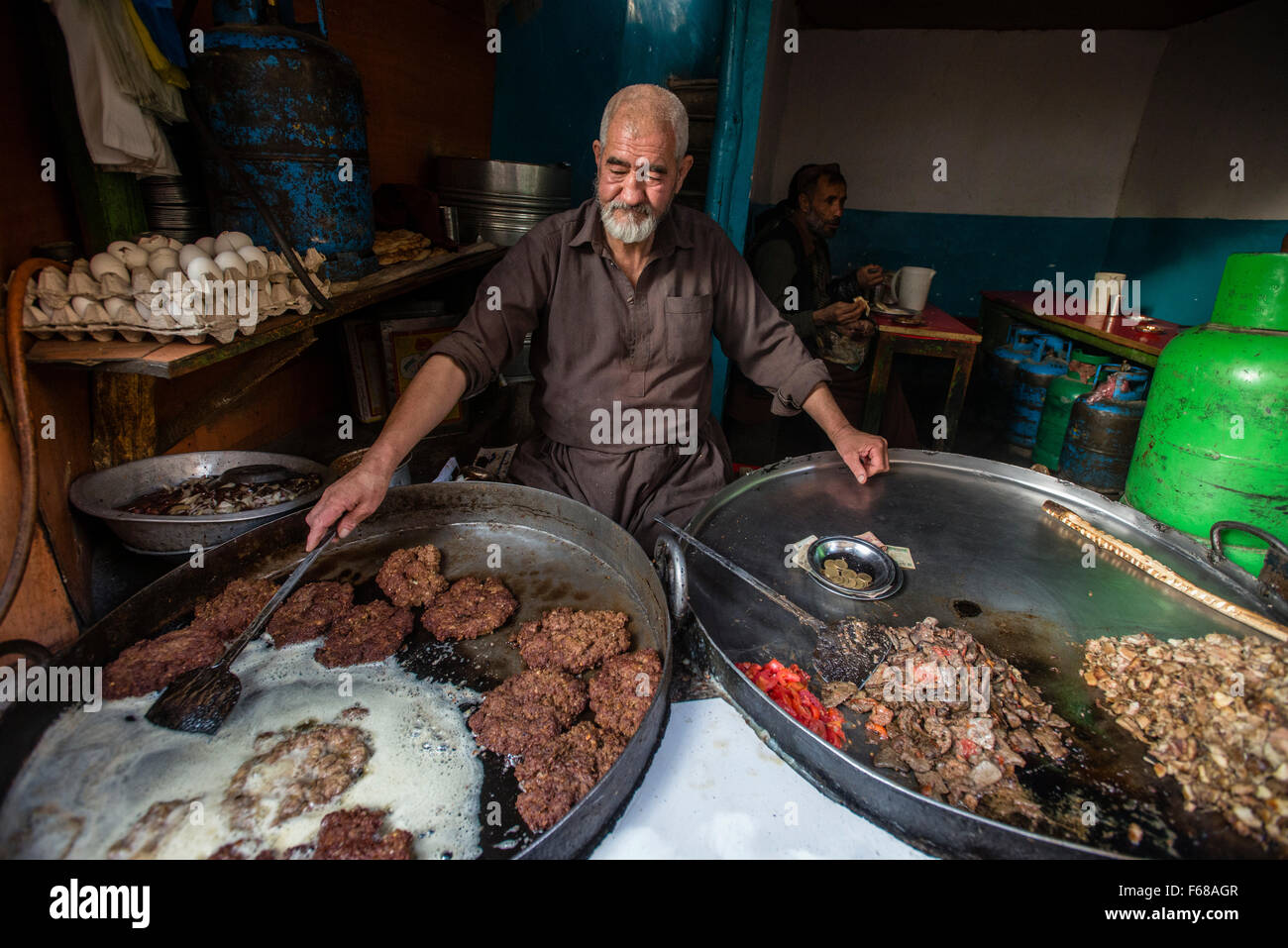 Ältere Menschen, die Zubereitung von Fleisch im traditionellen Restaurant des Ka Farushi Bird Market, Kabul, Afghanistan Stockfoto