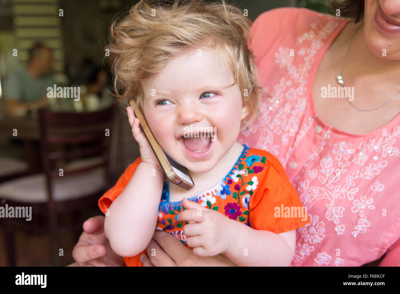 1 Jahr altes Baby sprechen auf einem Apple iPhone Stockfoto