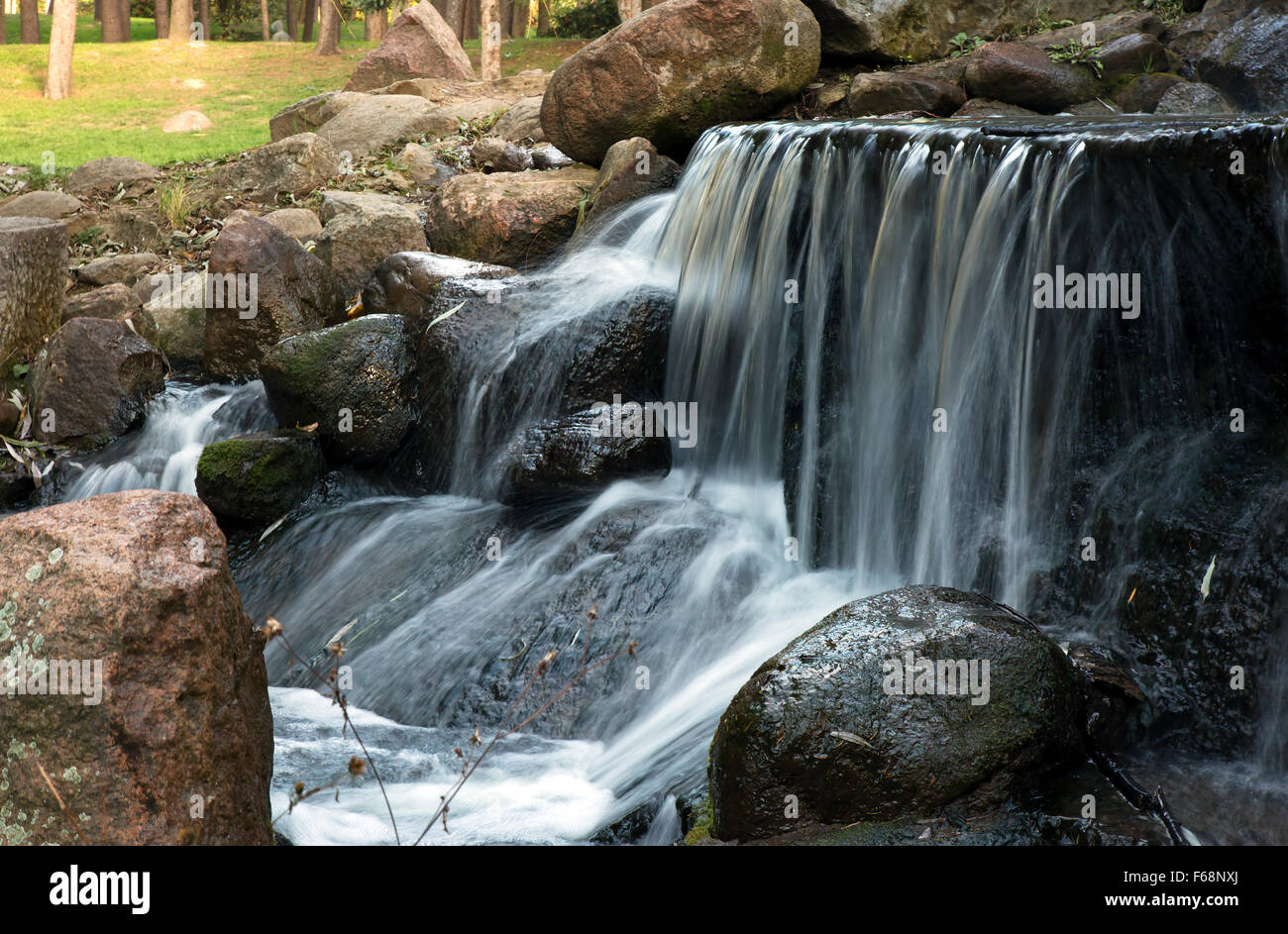 Poland.Park in Warsaw.Autumn.October.Small Wasserfall im Park. Sims mit dem Strom schwimmen. Wasser von oben die Steine fallen. Ho Stockfoto