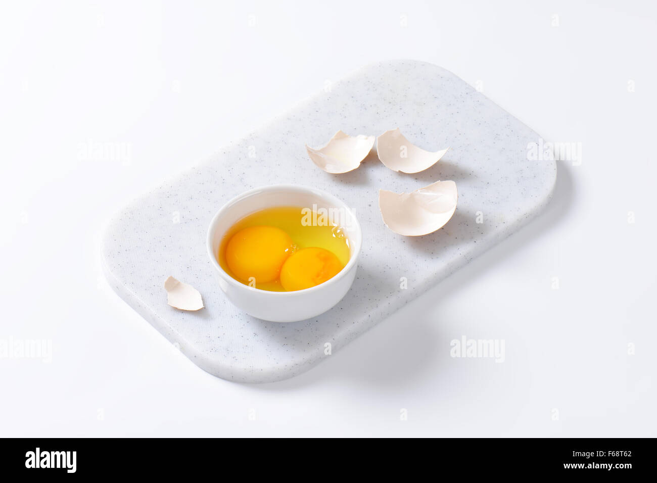Frisches Eiweiß und Eigelb in die Schüssel weiß Stockfoto