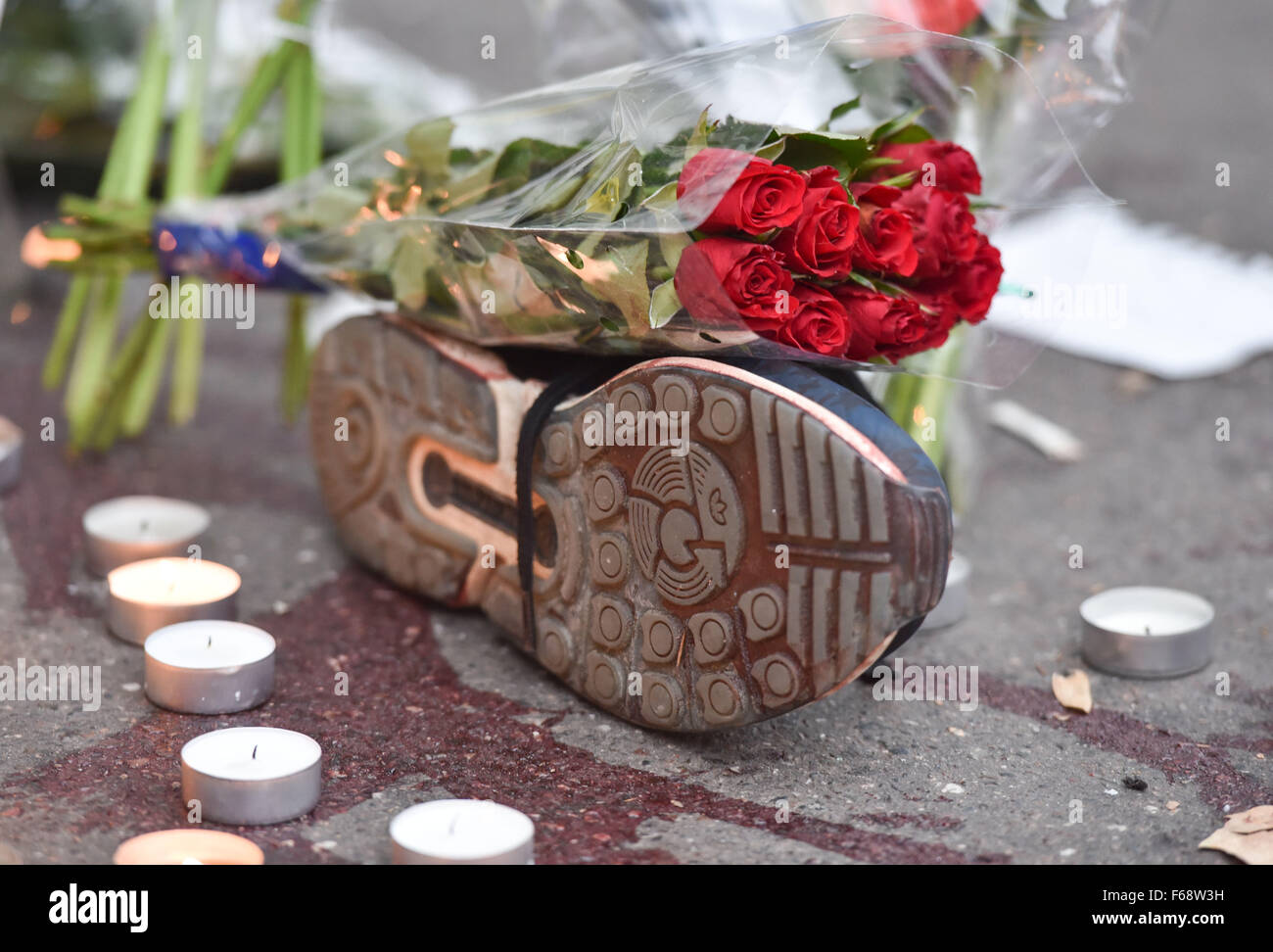 Paris, Frankreich. 14. November 2015. Rote Rosen auf einem Sportschuh, neben einer Blutspur, außerhalb des Bataclan-Musik-Club in Paris, Frankreich, 14. November 2015. In einer Reihe von Terroranschlägen in Paris sind mindestens 120 Menschen getötet worden. Foto: UWE ANSPACH/DPA/Alamy Live-Nachrichten Stockfoto