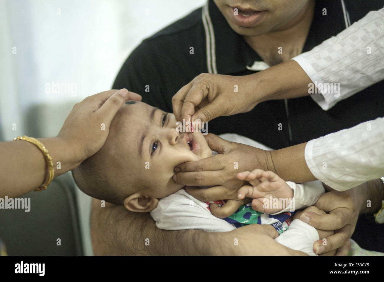 Dhaka, Bangladesch. 14. November 2015. DHAKA, Bangladesch-14. November: ein Säugling ist verabreicht wird Vitamin A in einer Gemeinschaft-Klinik in Dhaka im Rahmen einer bundesweiten Kampagne in Dhaka am 14. November 2015 '' ˜Vitamin-A Plus Kampagne über Bangladesch begonnen hat, mit Kindern zwischen sechs Monaten und fünf Jahren eine lebensrettende Kapsel zugeführt wird. Menschen, die mit ihren Kindern in Dhaka.Restriction Warteschlange: Deutschland, Österreich und der Schweiz rechts raus. © Zakir Hossain Chowdhury/ZUMA Draht/Alamy Live-Nachrichten Stockfoto