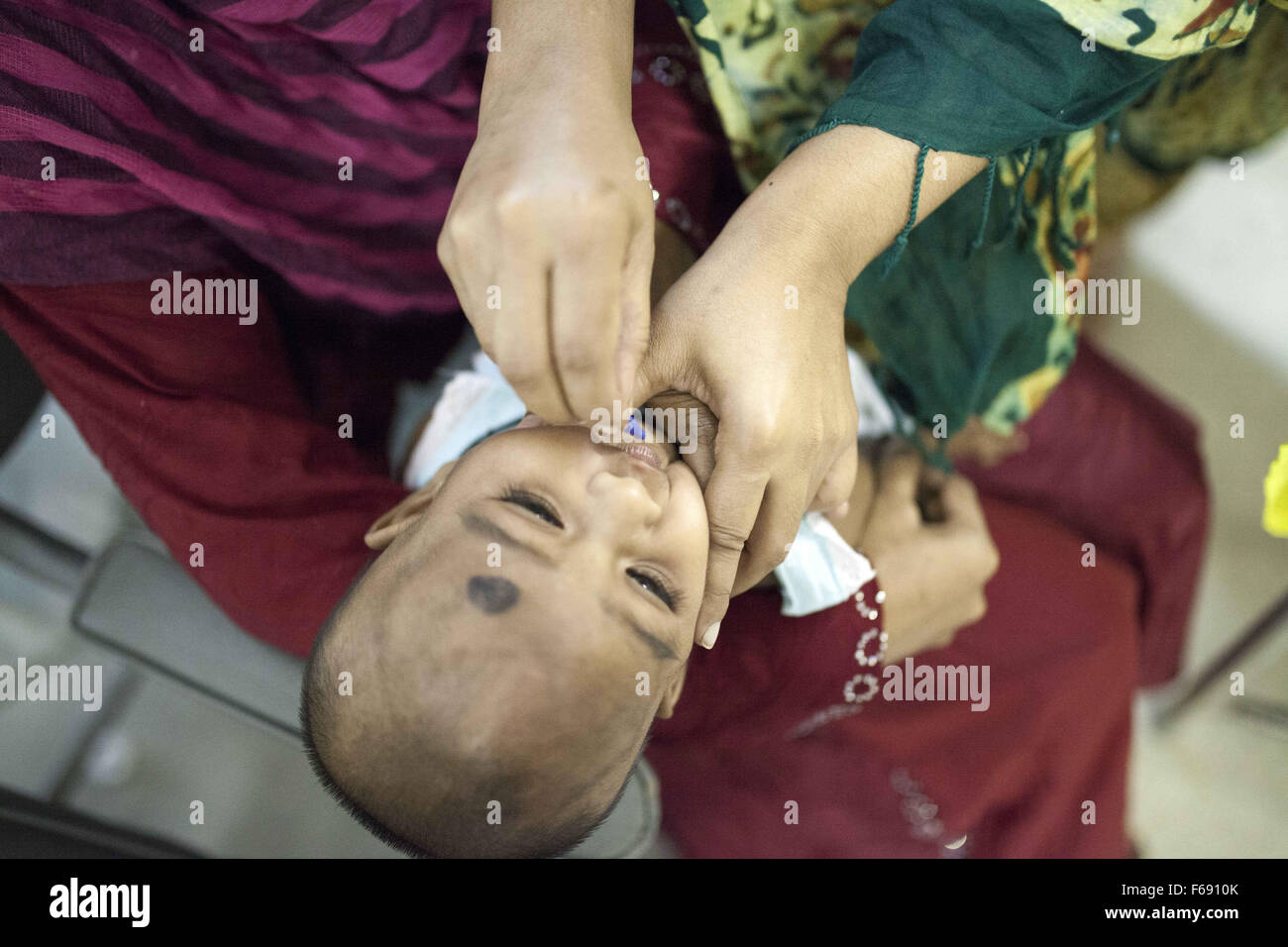 Dhaka, Bangladesch. 14. November 2015. DHAKA, Bangladesch-14. November: ein Säugling ist verabreicht wird Vitamin A in einer Gemeinschaft-Klinik in Dhaka im Rahmen einer bundesweiten Kampagne in Dhaka am 14. November 2015 '' ˜Vitamin-A Plus Kampagne über Bangladesch begonnen hat, mit Kindern zwischen sechs Monaten und fünf Jahren eine lebensrettende Kapsel zugeführt wird. Menschen, die mit ihren Kindern in Dhaka.Restriction Warteschlange: Deutschland, Österreich und der Schweiz rechts raus. © Zakir Hossain Chowdhury/ZUMA Draht/Alamy Live-Nachrichten Stockfoto