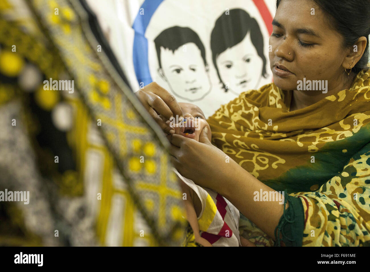 Dhaka, Bangladesch. 14. November 2015. DHAKA, Bangladesch-14. November: ein Säugling ist verabreicht wird Vitamin A in einer Gemeinschaft-Klinik in Dhaka im Rahmen einer bundesweiten Kampagne in Dhaka am 14. November 2015 '' ˜Vitamin-A Plus Kampagne über Bangladesch begonnen hat, mit Kindern zwischen sechs Monaten und fünf Jahren eine lebensrettende Kapsel zugeführt wird. Menschen, die mit ihren Kindern in Dhaka.Restriction Warteschlange: Deutschland, Österreich und der Schweiz rechts raus. © Zakir Hossain Chowdhury/ZUMA Draht/Alamy Live-Nachrichten Stockfoto