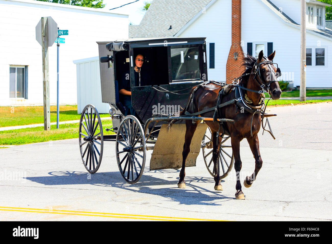 Amische Pferd und Buggy auf dem Weg in eine kleine ländliche Gemeinde in Wisconsin Stockfoto