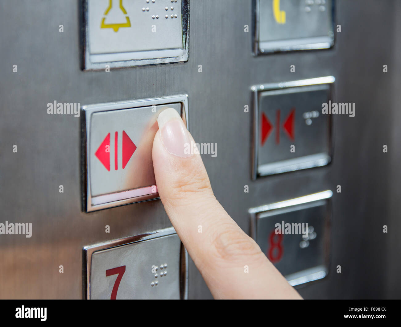 Hand drücken Sie offene Tür im Aufzug Stockfoto