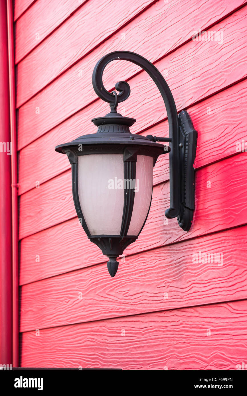 Alte Lampe auf roten Holz Wand Stockfoto