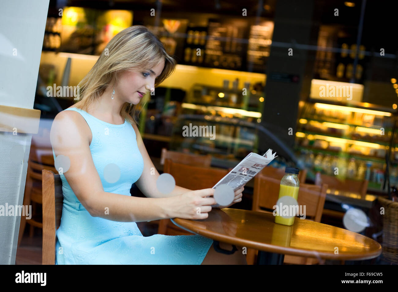 junge Frau liest die Zeitung in einem Coffee-shop Stockfoto