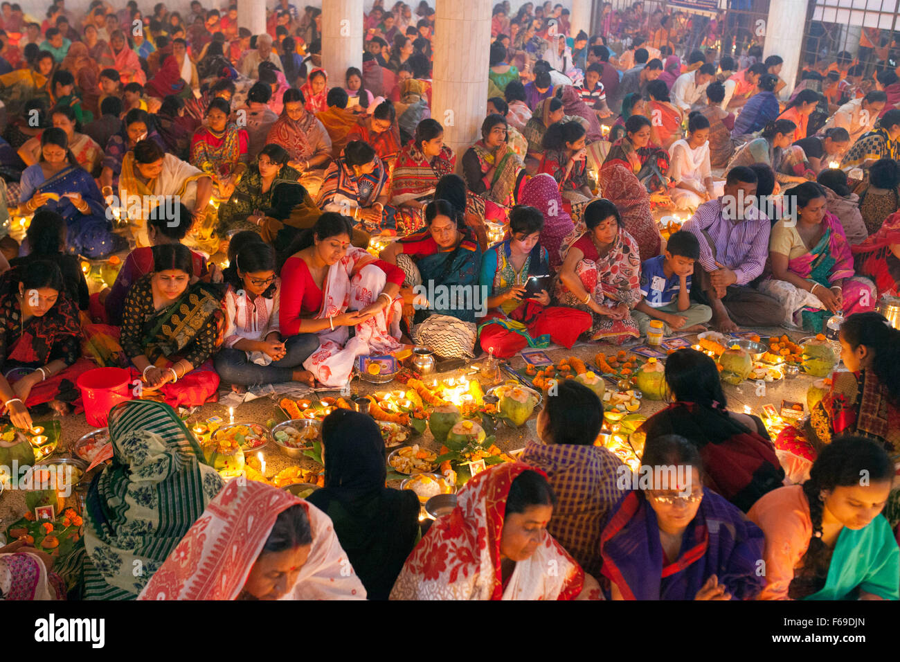 DHAKA, Bangladesch-14. November: Anhänger besuchen Gebet mit brennendem Weihrauch und leichte Öl-Lampen vor Pause Fasten während eines religiösen Festes Rakher Upabash in Dhaka am 14. November 2015 genannt. Bengali Leute des hinduistischen Glaubens in Bangladesch sitzen im Gebet feiern im 18. Jahrhundert hinduistischen Heiligen Baba Lokenath mit "Rakher Upobas" Gebet und Fastentag jedes Jahr Tausende von hinduistischen Anhänger versammeln sich vor Shri Shri Lokenath Ramakrishna Ashram Tempel für das Kartik Brati oder Rakher Upobash religiöse fest in Barodi, in der Nähe von Dhaka, Bangladesh. Gläubigen sitzen vor Kerzen Licht (name Stockfoto